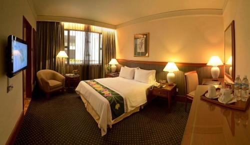 Un pat sau paturi într-o cameră la The Jesselton Hotel