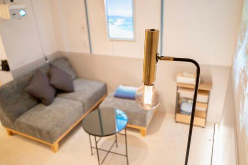 a living room with a couch and a table at Blue Nest Takamatsu in Takamatsu