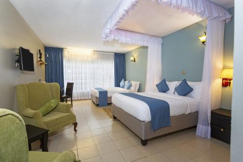 a hotel room with two beds and a chair at Lukenya Motorcross in Machakos