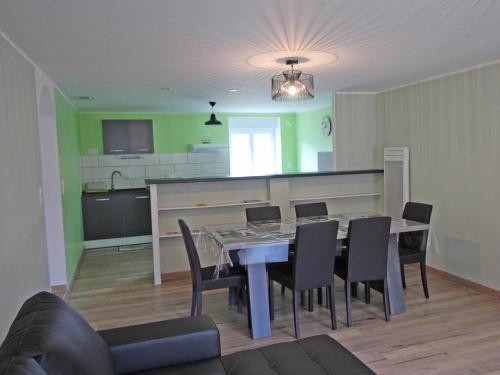 une salle à manger avec une table et des chaises et une cuisine dans l'établissement La treille, à Saint-Hilaire-La-Treille