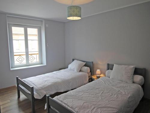 une chambre avec deux lits et une fenêtre dans l'établissement La treille, à Saint-Hilaire-La-Treille