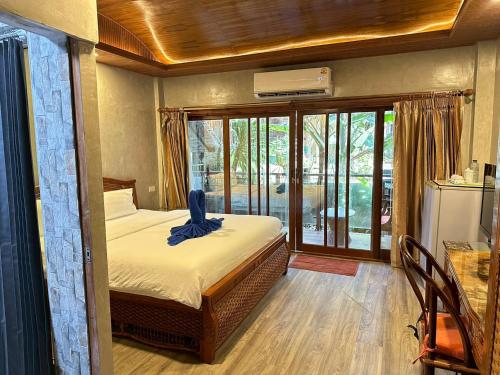 ein Schlafzimmer mit einem Bett und einem großen Fenster in der Unterkunft Anda Resort in Ko Lipe