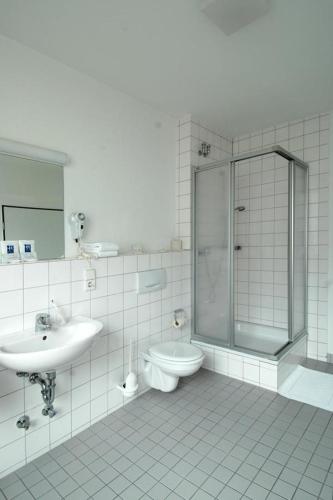 a bathroom with a shower and a toilet and a sink at CVJM Düsseldorf Hotel & Tagung in Düsseldorf