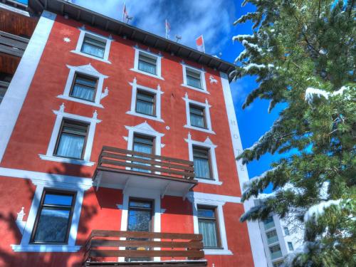 un edificio rojo con un balcón en el lateral. en arthausHOTEL, en Davos