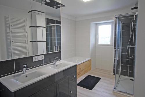 a white bathroom with two sinks and a shower at Le monteil in Saint-Sornin-Leulac