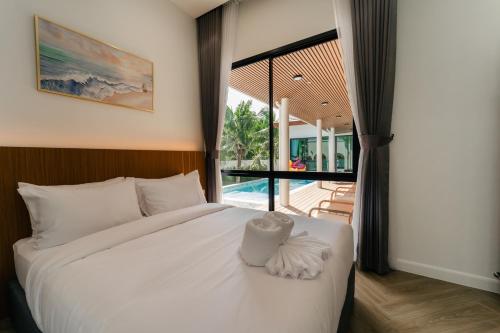 a bedroom with a bed and a view of a pool at PHUM Villa Songkhla in Ban Saphan Yao