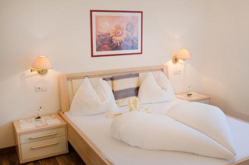 a bedroom with a white bed with a teddy bear on it at Residence Reinhild in Nalles