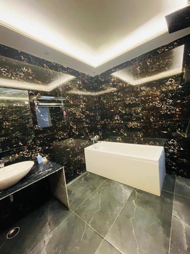 a bathroom with a sink and a bath tub at MK House in Greater Noida