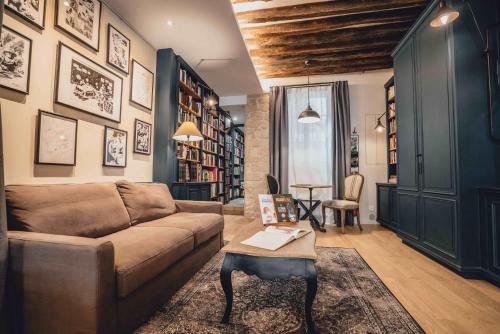 a living room with a couch and a table at La suite heart of le Marais - quartier des enfants rouges in Paris