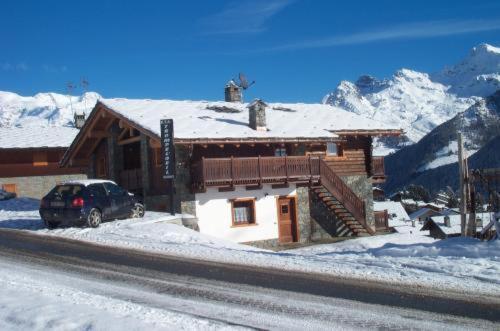 a car parked in front of a house in the snow at Residence Trompe-L'oeil in Champoluc