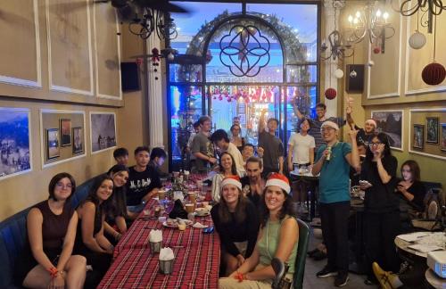 a group of people sitting at a table in a restaurant at Little Charm Hanoi Hostel in Hanoi