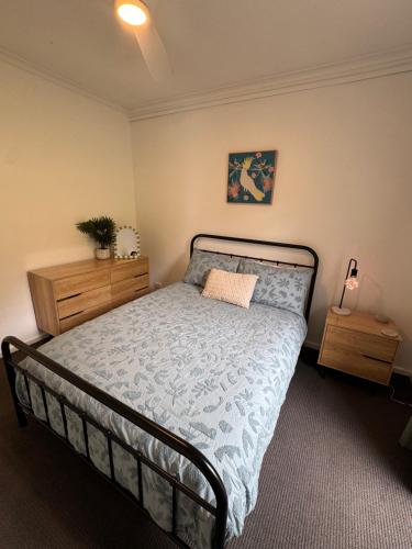a bedroom with a bed with a blue comforter at Teringie Retreat with Breathtaking Views in Norton Summit