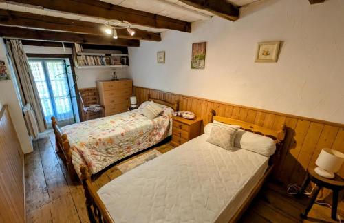 a bedroom with two beds and a window at La ferme des souvenirs in Vaulry