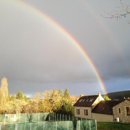 a rainbow in the sky over a house at Cottage de La Mothe in Marnac