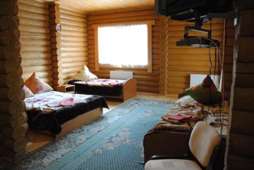 Cette chambre comprend 2 lits et une télévision dans une cabane en rondins. dans l'établissement Крокус Мія, à Slavsko