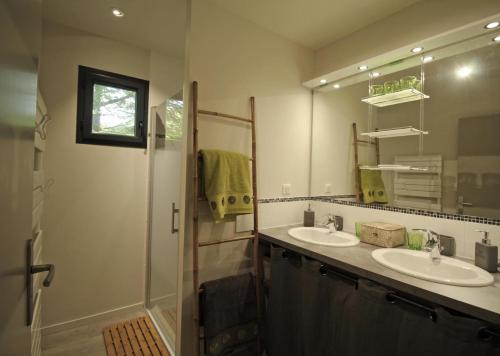 a bathroom with two sinks and a shower with a mirror at Trois ânes et un moulin in Bessines-sur-Gartempe