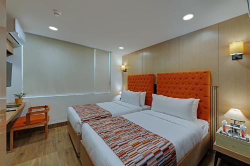 a hotel room with a large bed and a desk at AR Suites Sohna Road in Gurgaon