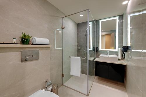 a bathroom with a shower and a toilet and a sink at AR Suites Sohna Road in Gurgaon
