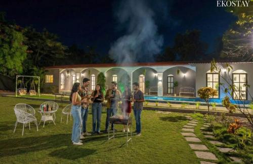 a group of people standing in front of a house at EKOSTAY Luxe - Casa Roma in Alibaug