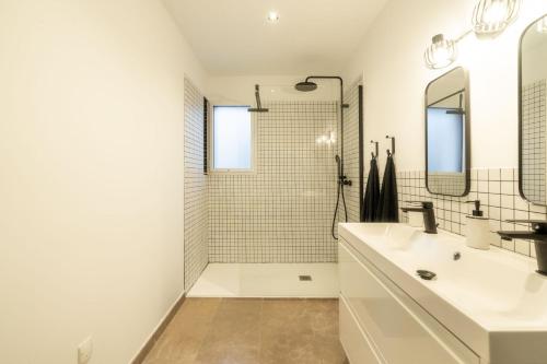 a white bathroom with a sink and a shower at Maison Jeannot - Climatisée avec piscine in Vers Pont du Gard