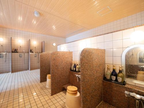 a bathroom with several stalls with bottles of wine at Fuji Matsuzono Hotel in Yamanakako