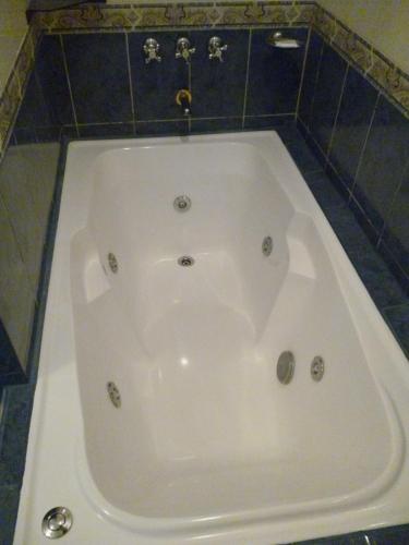 a large white bath tub in a bathroom at Hotel Benevento in La Plata