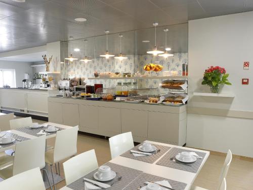 a restaurant with tables and chairs and a buffet at Cova da Iria Hotel in Fátima