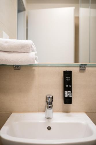 a bathroom sink with a soap dispenser next to a mirror at Homaris Nolli Studios in Berlin
