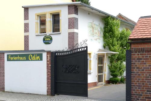 a white house with a black garage door at Ferienhaus ODIN in Großräschen