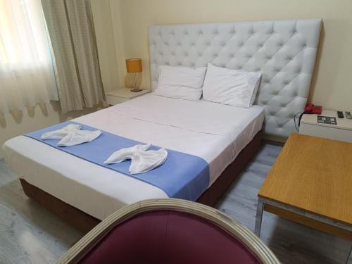 a bedroom with a bed with two towels on it at Elflora Otel in Ceyhan