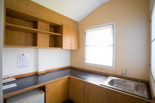 a small kitchen with a sink and a window at Brookside Valley Resort in Rayong