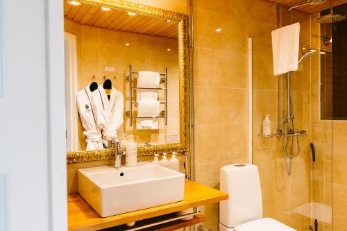 a bathroom with a sink and a shower and a mirror at Boutique Hotel Yöpuu in Jyväskylä