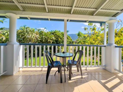 a table and two chairs on a porch with a view at Coral Mango in Airlie Beach