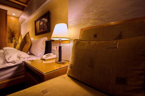 a bedroom with a bed and a lamp on a table at Waikoloa Hotel in Taipei