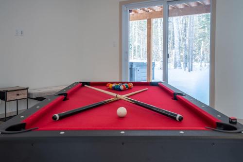 a red pool table with cue balls on it at Spa Pool Table & Comfort - Chalet le Barista in Brownsburg