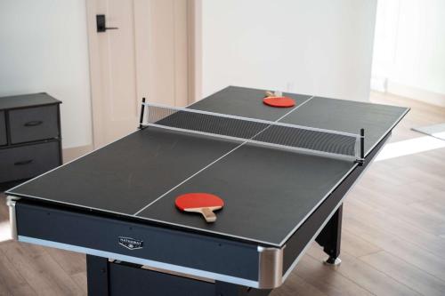 a ping pong table with two ping pong balls on it at Spa Pool Table & Comfort - Chalet le Barista in Brownsburg