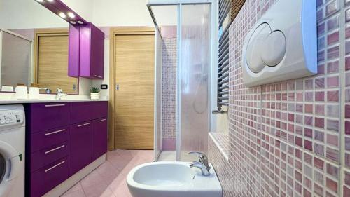 a bathroom with purple cabinets and a sink at Nido Alpino - casetta con giardino, vista montagne in Tirano