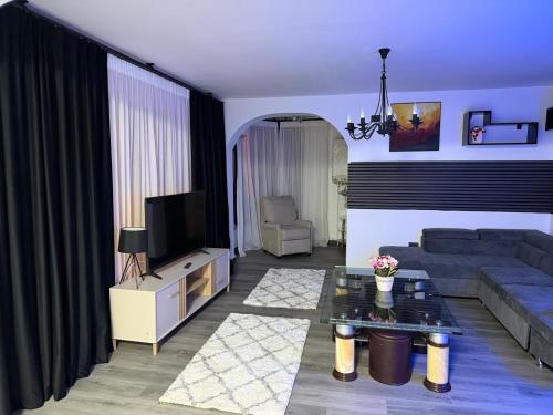 a living room with a couch and a tv at Central Villa in Craiova