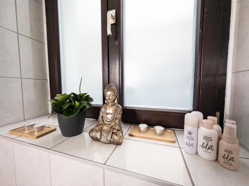 a small statue sitting on a bathroom counter in front of a mirror at Erstklassige 3-Zimmer Wohnung in Leipzig
