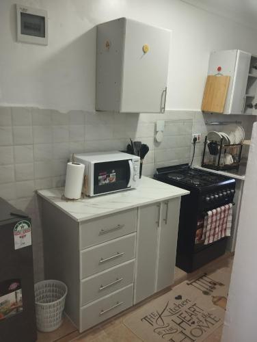 a kitchen with a microwave on top of a counter at Luxe homes in Munyu