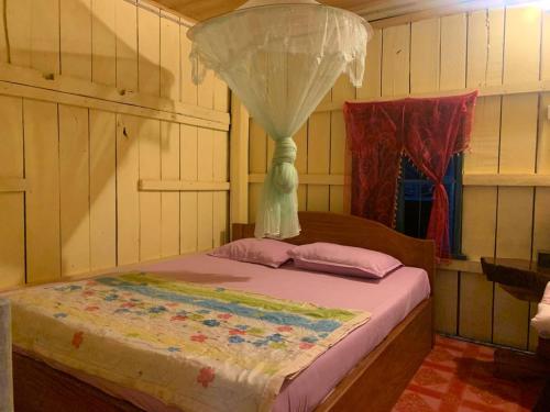 កុយ ឡាយ-Koy Lay في Chi Phat: غرفة نوم بها سرير عليه ستارة