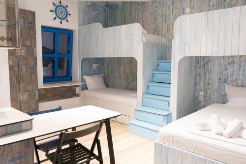 a room with two bunk beds and a desk at ELPIDA Suites - Mandra, Greece in Mándra