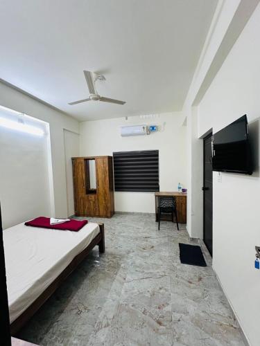 a bedroom with a bed and a flat screen tv at Dubai Inn in Kanjirapalli