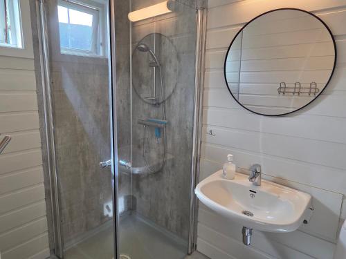a bathroom with a shower and a sink and a mirror at Vassel gård in Herand