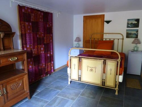 a small room with a bed and a dresser at Gîte Chez Dimanche in Essert