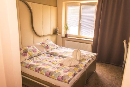 um pequeno quarto com uma cama e um espelho em Penzion Relaxko em Fulnek