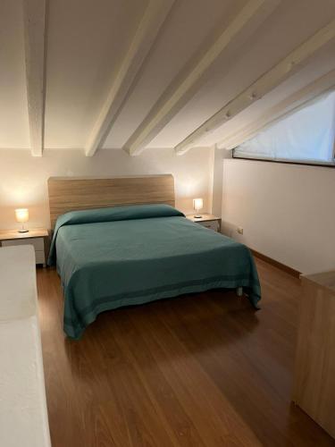 a bedroom with a green bed and two night stands at Hotel Antica Fenice in Campalto