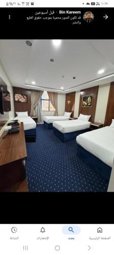 a train room with three beds and a desk at Maysan Al Mahbas Hotel in Al Khansāk
