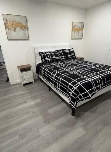 a bedroom with a black and white bed and a table at Family Home WITH 3 BR & 1RR in Grand Prairie