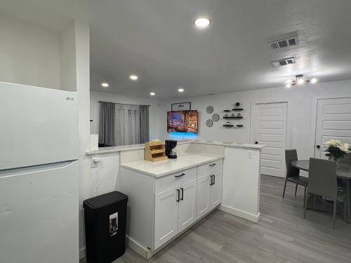 a kitchen with white cabinets and a dining table at Family Home WITH 3 BR & 1RR in Grand Prairie